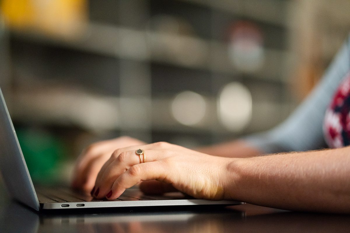 woman's hands typing on a laptop