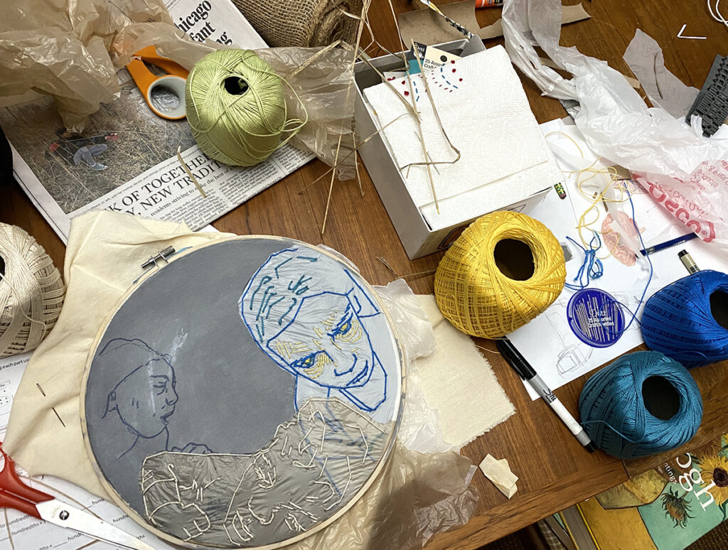 embroidery hoop work in progress and scattered supplies